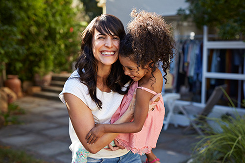 Woman smiling while holding little girl