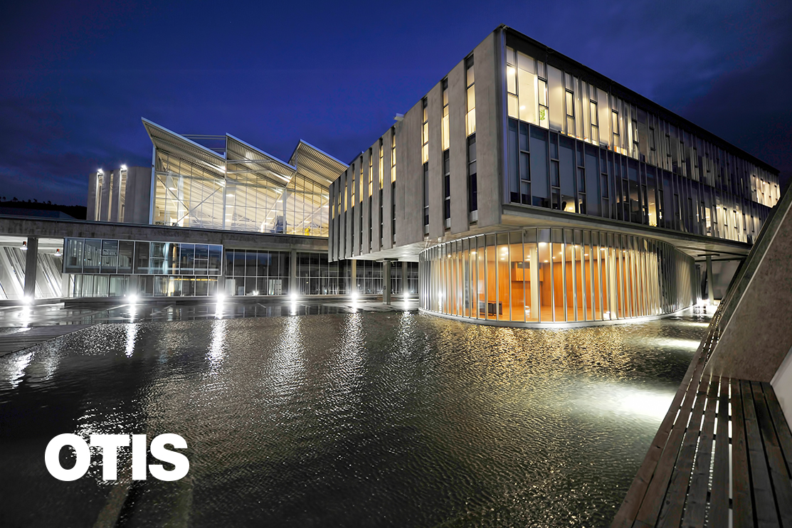 Building at dusk with water in foreground 