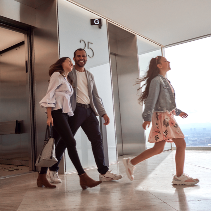 People smiling as they exit an elevator